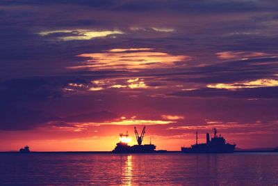 Silhouette of ship sailing in sea at sunset