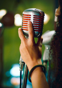 Cropped image of woman singing on microphone