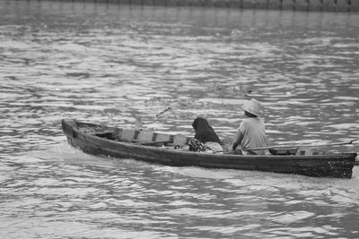 Men sitting on boat in river
