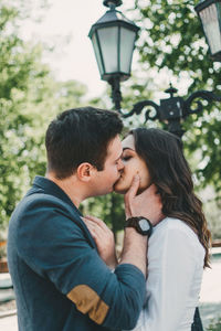 Side view of couple kissing outdoors