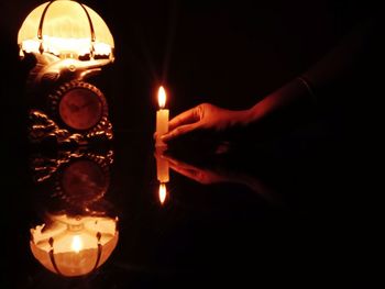 Reflection of person hand on illuminated lamp