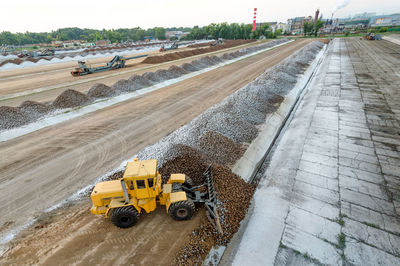 Earth mover at construction site against sky