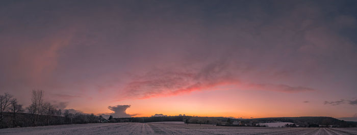 Scenic view of snow covered landscape against sky during sunset