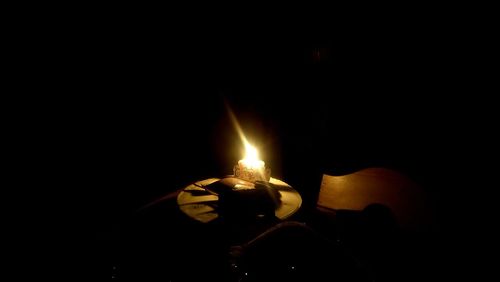 Close-up of burning candle in darkroom