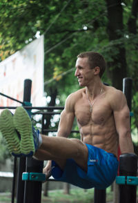 Shirtless man exercising in gym