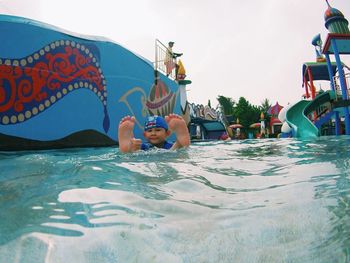 Portrait of shirtless man swimming in pool