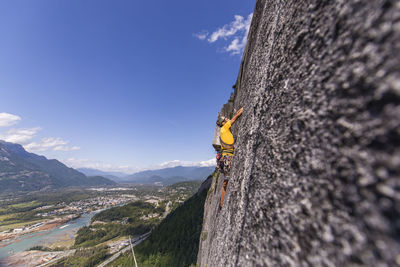 Side view man rock climbing squamish chief above the sea and highway