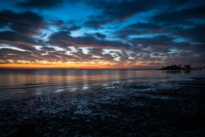 Scenic view of sea against dramatic sky during sunset