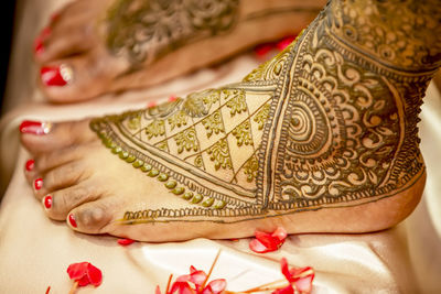 Indian bride's leg painted with henna on her wedding eve.