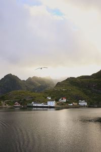 Scenic view of sea by mountains against sky