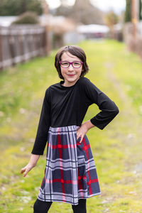 Portrait of smiling girl standing on mossy road