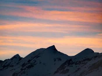 Scenic view of snowcapped mountains against sky during sunset