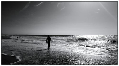 Man standing on beach against clear sky