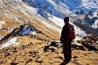 Rear view of man standing on snow covered landscape