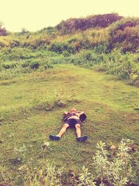 Full length of man relaxing on grassy field