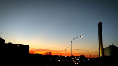 Silhouette of city street against clear sky