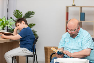 Side view of man using mobile phone while sitting at home