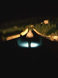 Man in illuminated water at night