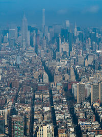 Aerial view of buildings in city against sky