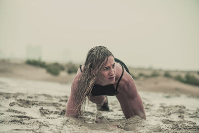 Portrait of woman on beach against clear sky