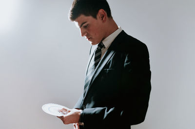 Man playing with cards while standing by wall