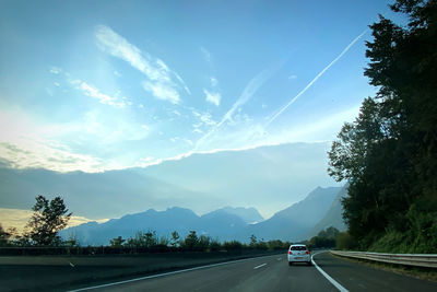 Road by mountains against sky