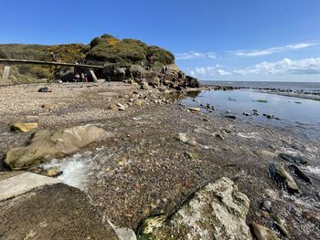 Rock formation on beach against sky