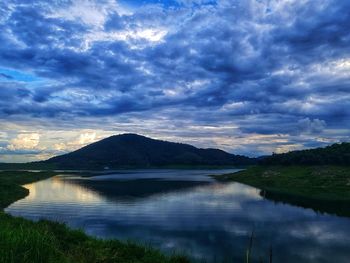 Scenic view of lake by mountains against sky