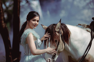 At sunset, a beautiful sensual girl and her horse go through the woods. horses are adored by girls.