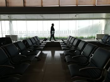 Rear view of silhouette man standing at airport