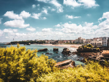 Scenic view of river by city against sky