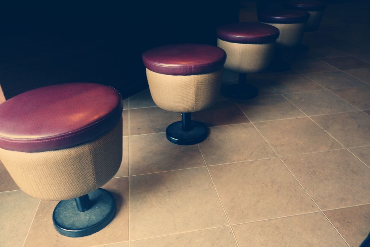 indoors, tiled floor, still life, table, high angle view, flooring, empty, tile, arrangement, absence, chair, no people, floor, wall - building feature, lighting equipment, variation, illuminated, shadow, home interior, large group of objects