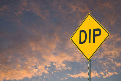 Low angle view of road sign against sky