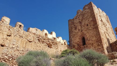 Low angle view of historical building against clear blue sky