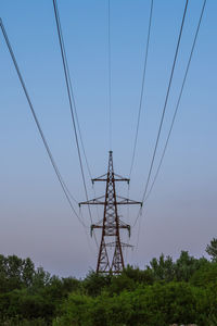 Low angle view of electricity pylon against clear sky