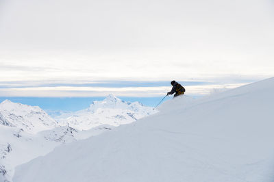 People skiing on snow covered landscape