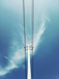 Low angle view of electricity pylon against blue sky