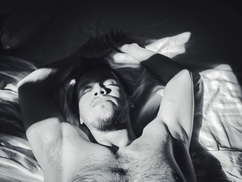 High angle view of man lying on bed