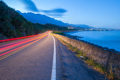 Road by mountain against sky at night