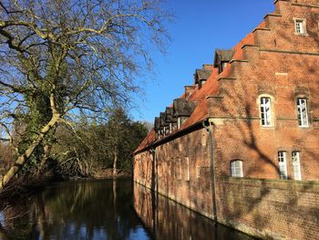 River amidst bare trees against clear sky
