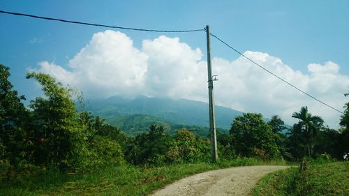 Country road against cloudy sky