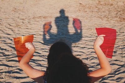 Low section of people relaxing on sand at beach