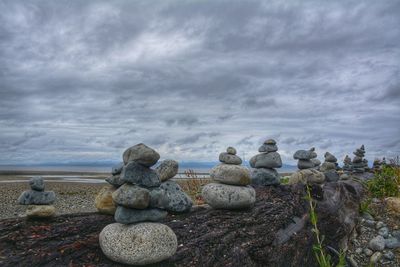 Stack of stones on land against sky