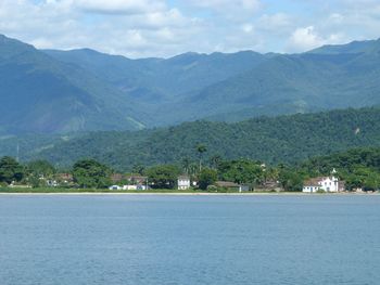 Scenic view of sea and mountains against sky