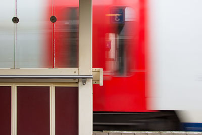 Blurred motion of red train at railroad station platform