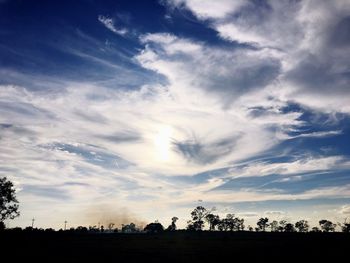 Silhouette trees on landscape against sky