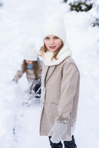 Portrait of girl standing on snow during winter