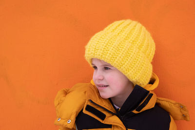 Portrait of girl wearing hat against yellow background