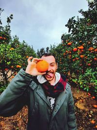 Portrait of man holding orange