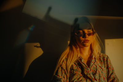 Portrait of a young woman wearing sunglasses during sunset